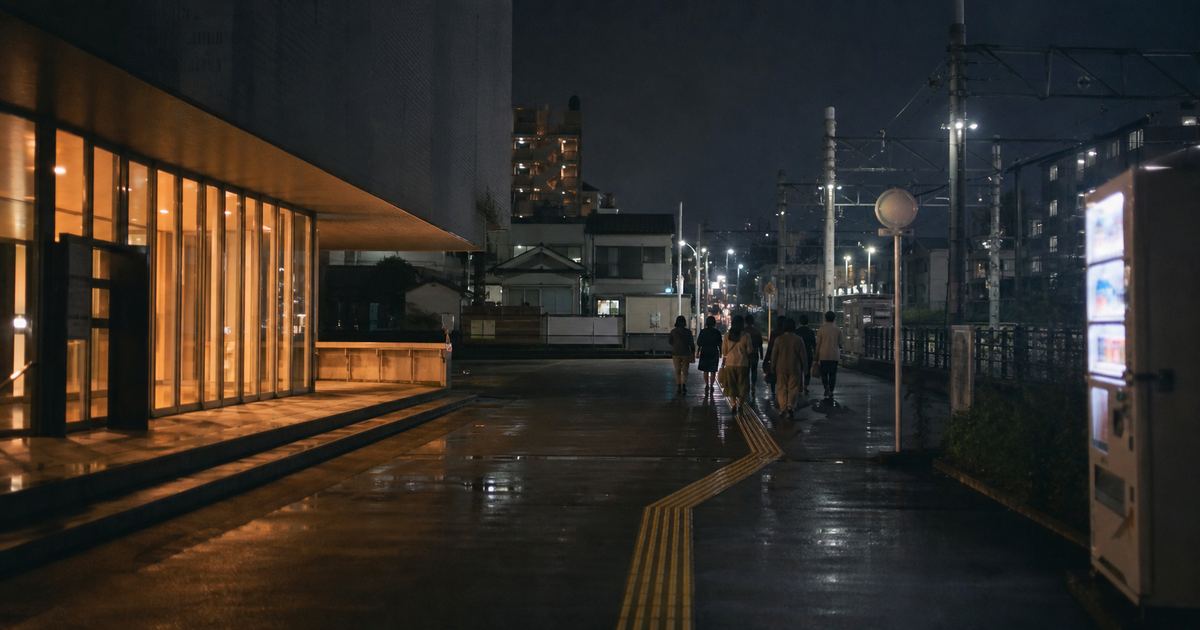 夜、ホールの明かりが漏れる通りを、観客がバス停へ向かって歩いている（イメージ）